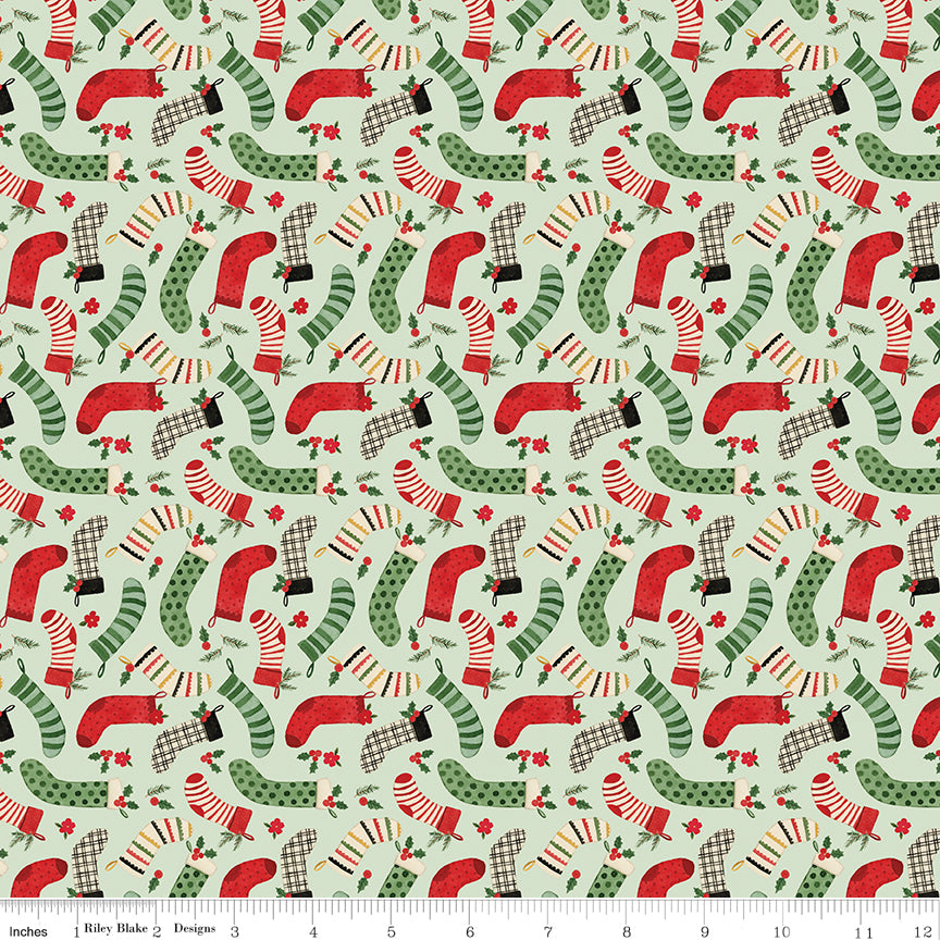 Pattern of red and green Christmas stockings on a light green background