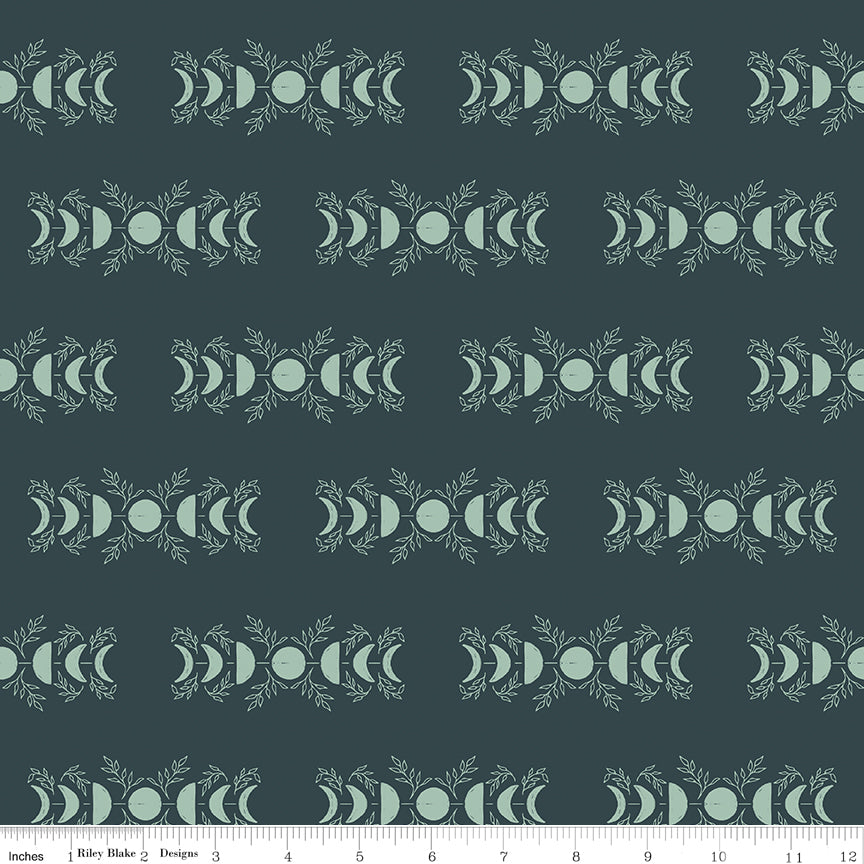 Pattern of moon phases on a dark green background with a ruler for scale.