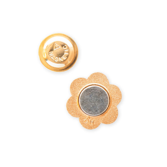 A flower-shaped rose gold magnetic button with a silver circular magnet in the center, shown alongside its back view which features an engraved 'MAGNET' label.
