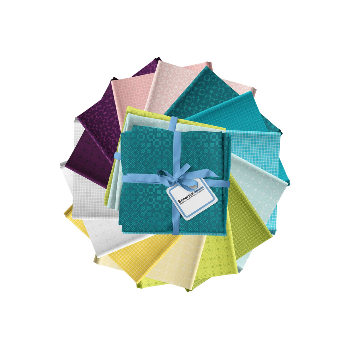 A circular arrangement of folded fabrics in multiple colors and patterns, with a teal quilt in the front tied with a blue ribbon and a blank label tag. The quilts include purple, pink, teal, light blue, yellow, and white patterns on a plain white background.