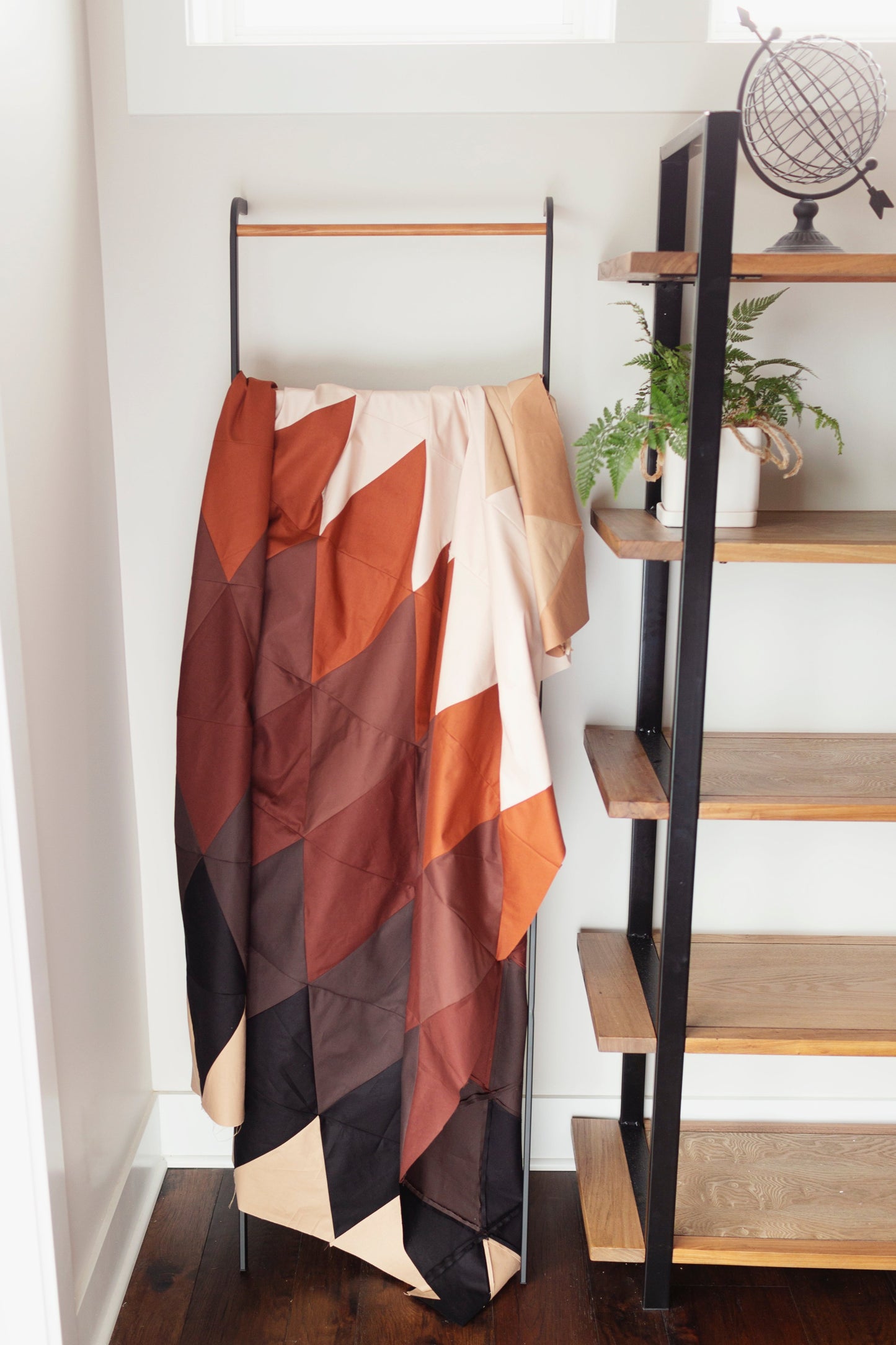 Ivy League Quilt top hanging on ladder