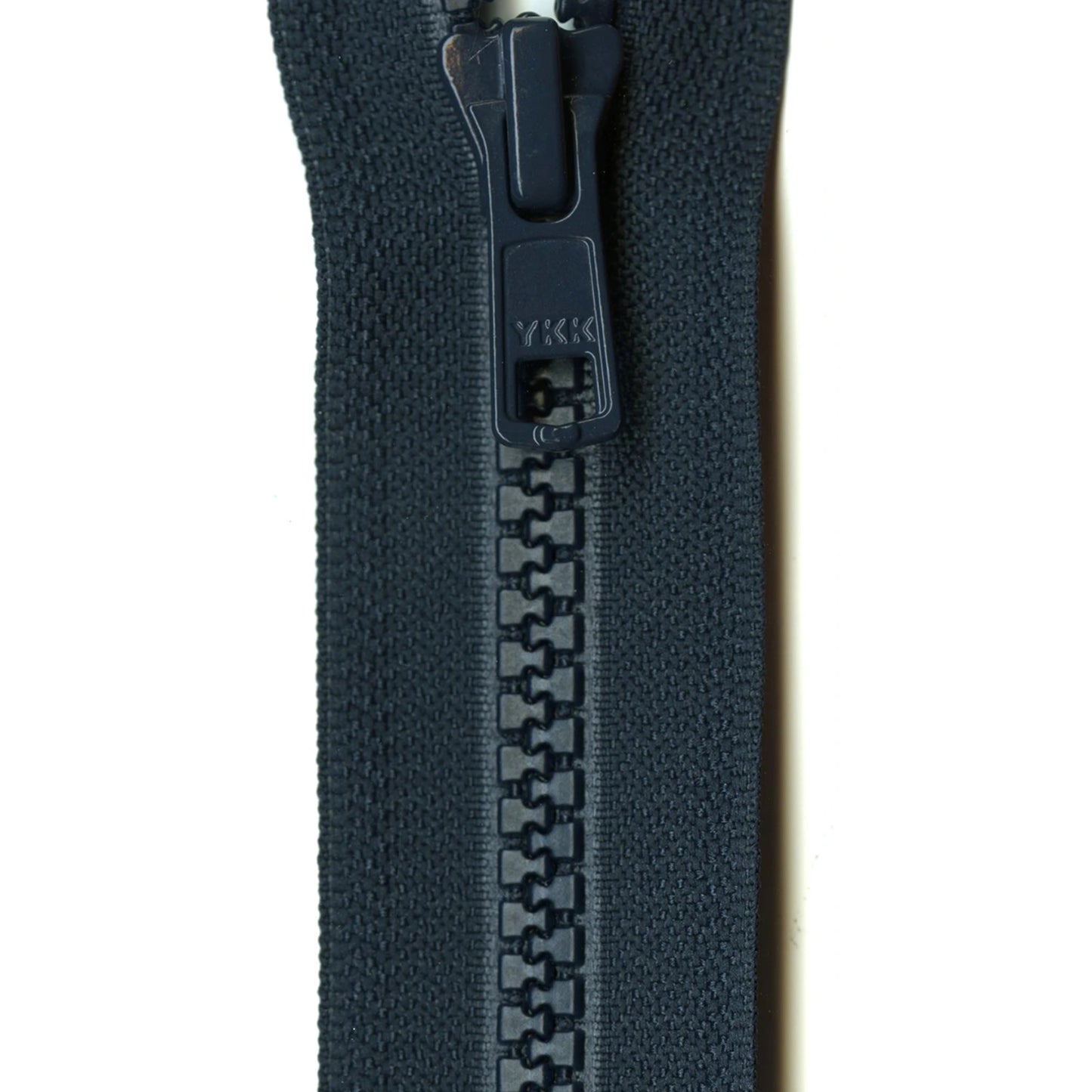 Close-up of a navy zipper on a white background
