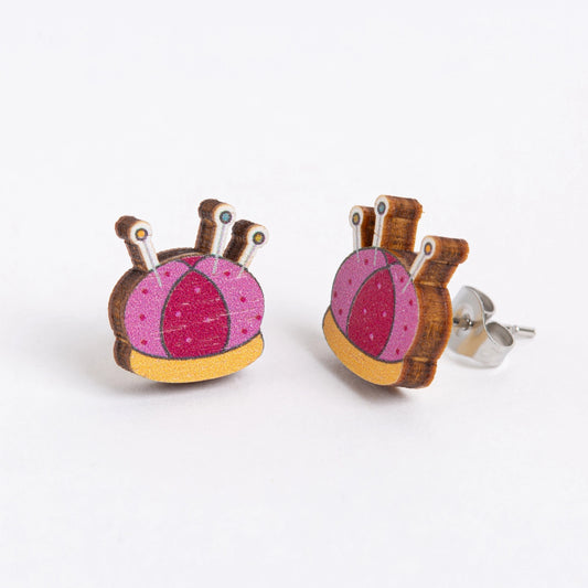 Pair of earrings with pink and brown design on a white background