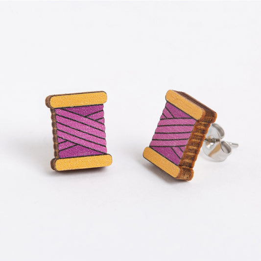 Wooden spool earrings with pink and purple striped design on a white background