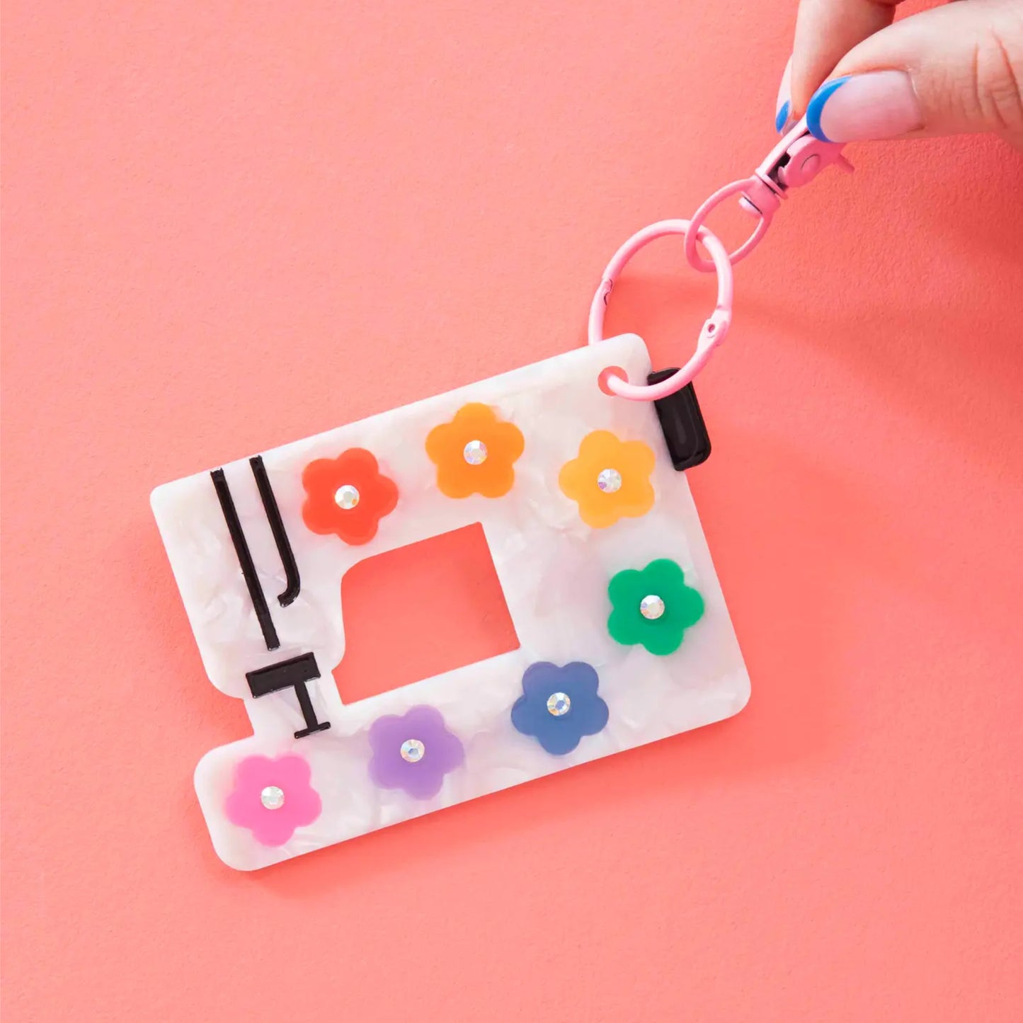 Keychain with sewing machine design and colorful flowers on a pink background