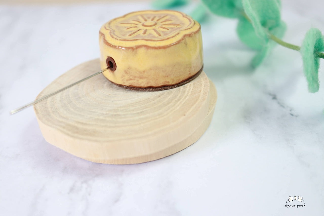 Ceramic flower magnetic needle minder featuring needle in polisher