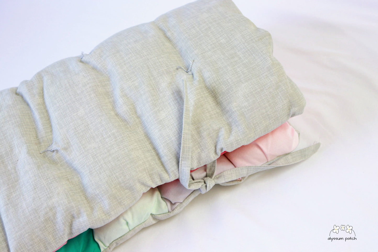 melon patchwork puff seat cushion folded and secured with ties for easy transport