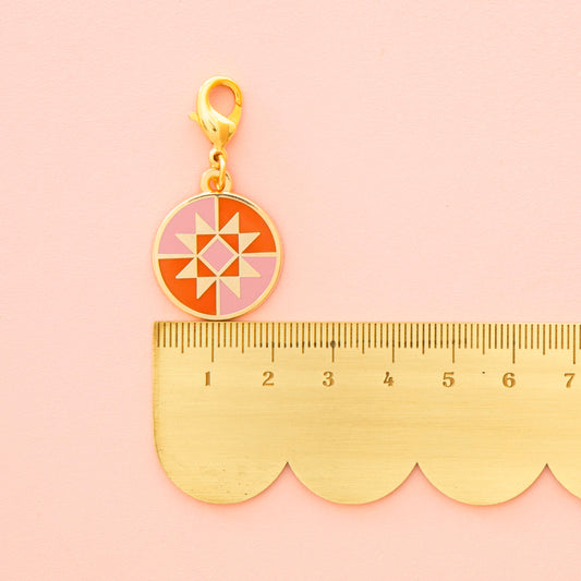 Geometric pendant with gold frame on a pink background