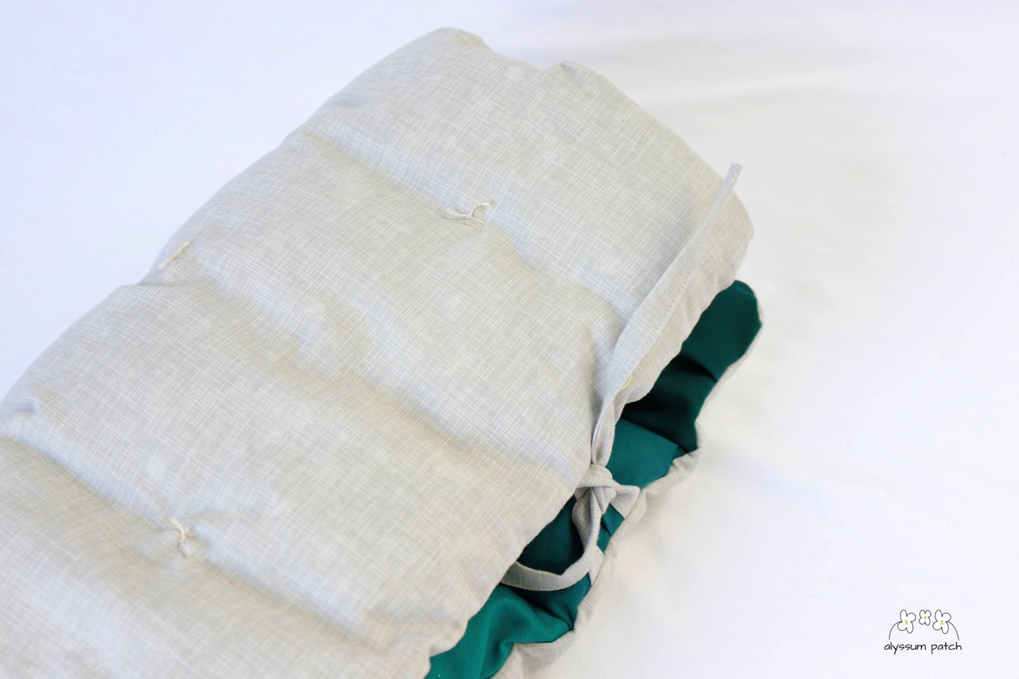 seaside patchwork puff seat cushion folded and secured with ties for easy transport