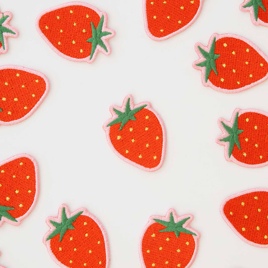 Pattern of strawberry-shaped patches on a white background