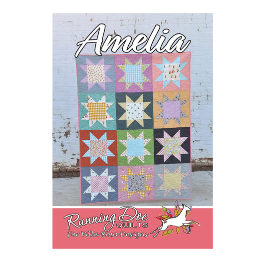 A quilt pattern cover titled 'Amelia' showing a colorful patchwork star quilt against a white painted wood wall, with the brand text 'Running Dog Quilts for Villa Rosa Designs' at the bottom.