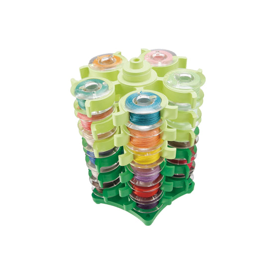 Stack of colorful spools in a green holder on a white background