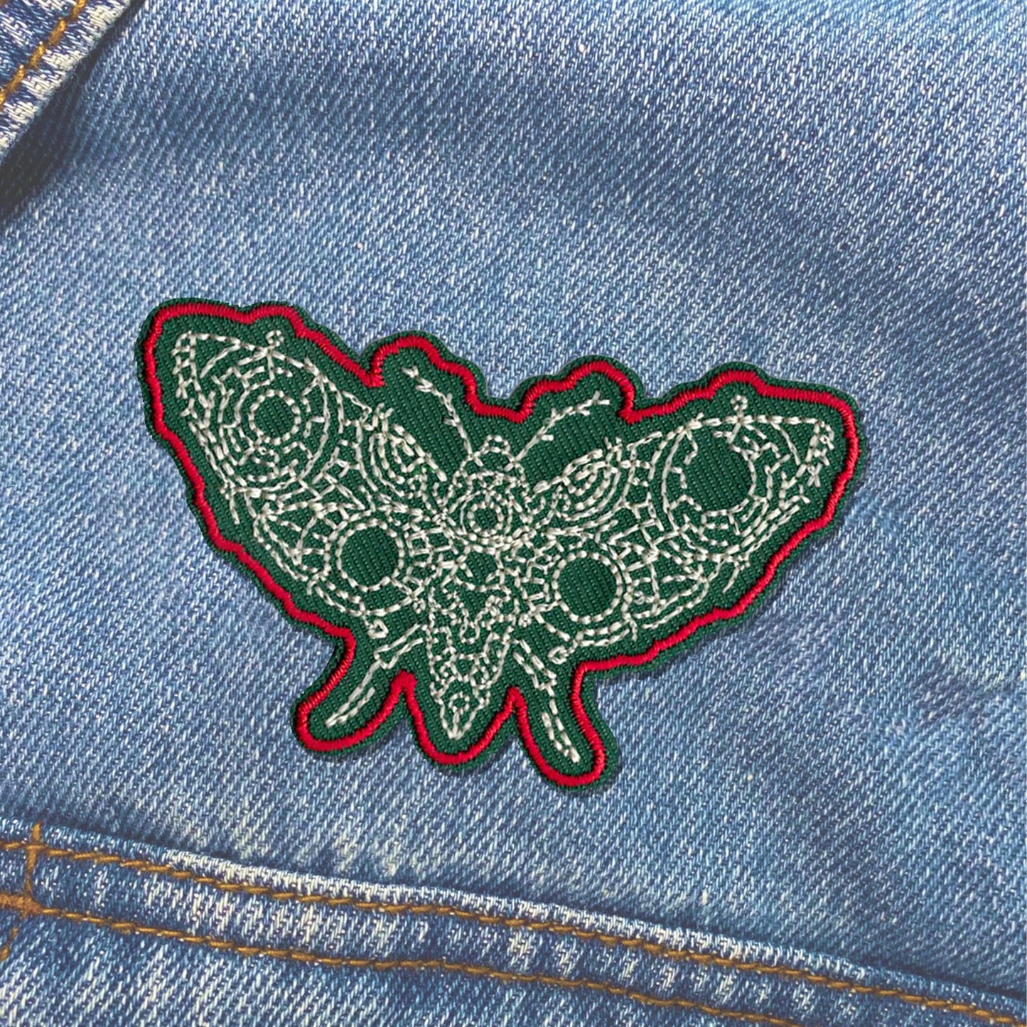 Green butterfly patch on a denim jacket