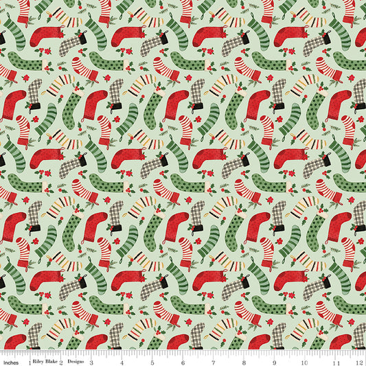 Pattern of red and green Christmas stockings on a light green background