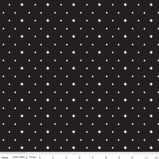 Black fabric with white star pattern and a ruler at the bottom for scale.