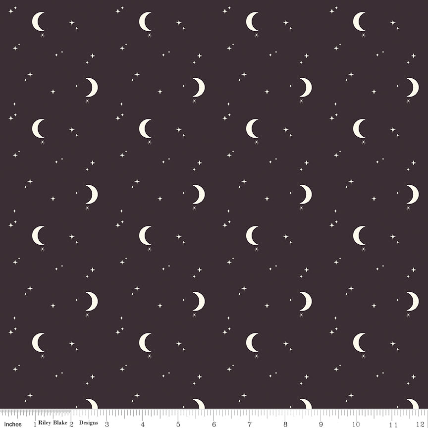 Pattern of crescent moons and stars on a dark background with a ruler at the bottom.
