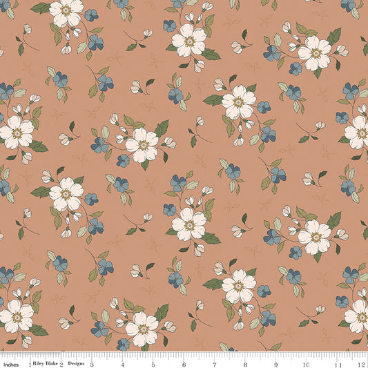 A repeating floral pattern on a warm peach background, featuring large white blossoms, smaller blue flowers, and green leaves. A ruler along the bottom edge shows scale, and the text 'Riley Blake Designs' is visible in the lower left corner.
