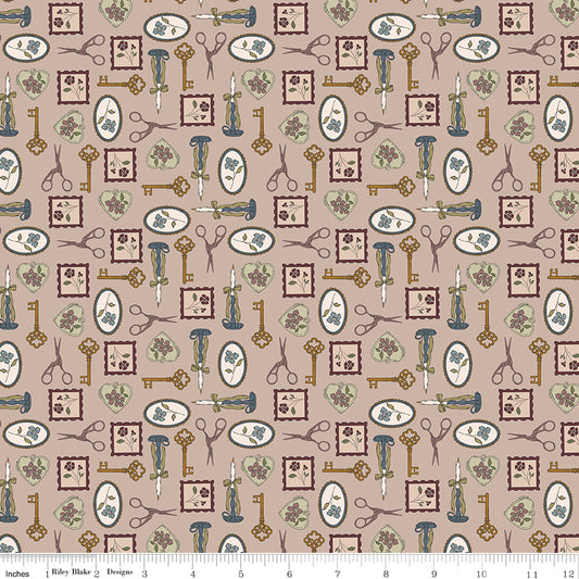 A repeating fabric pattern on a warm taupe background featuring vintage-style keys, scissors, framed floral motifs, and small botanical illustrations in muted blue, olive green, and brown. A white ruler along the bottom edge shows the scale of the print.