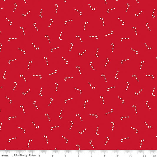 Red fabric with a repeating pattern of small white candy cane motifs and a 12-inch ruler along the bottom edge.