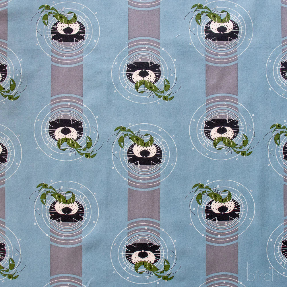 Patterned fabric with otters on a blue background
