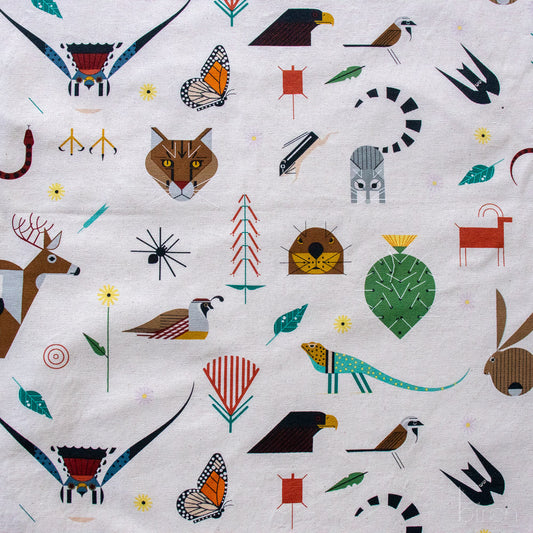Patterned fabric with various animals, plants, and abstract shapes on a white background
