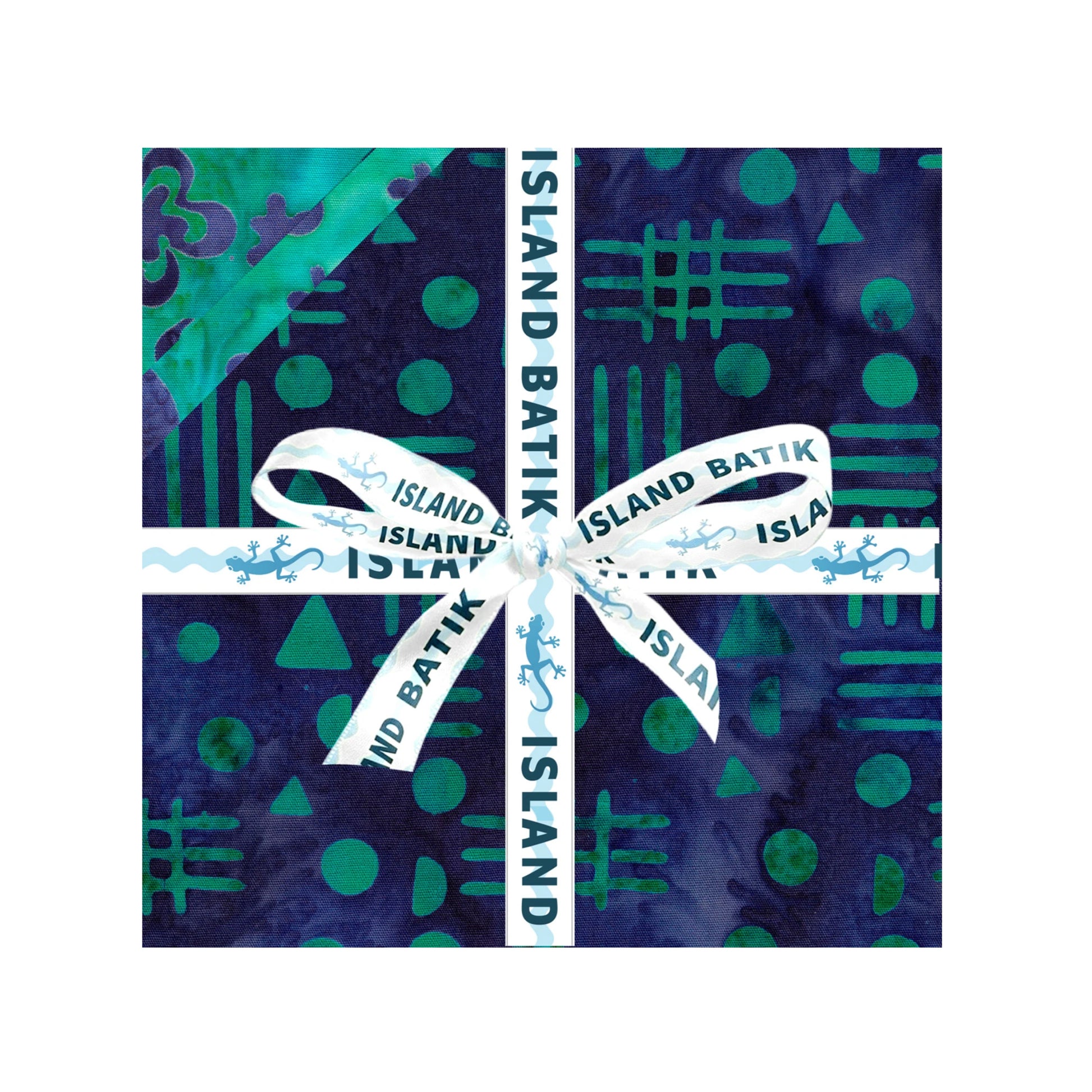 A square fabric sample or swatch with a batik-style pattern in deep navy and teal, wrapped with a white ribbon printed with 'ISLAND BATIK' and tied in a bow at the center, shown on a plain white background.