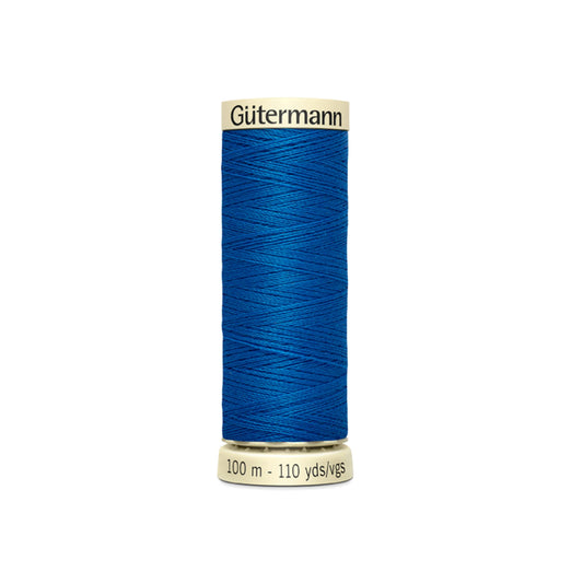 Blue spool of Gütermann thread on a white background
