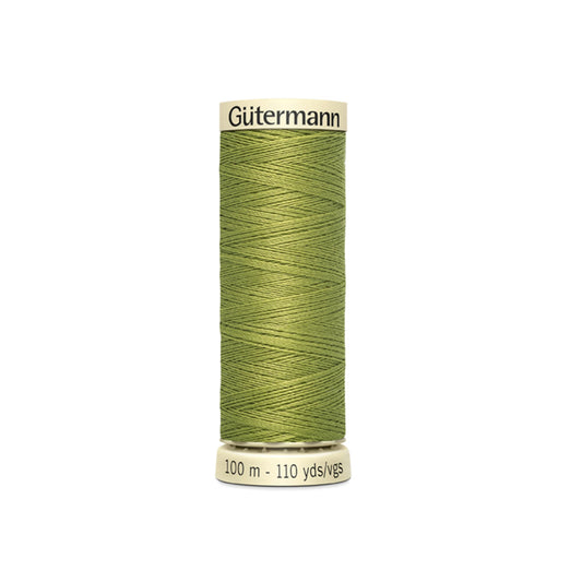 Green spool of Gutermann thread on a white background