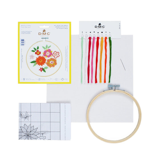 Embroidery kit with floral design chart, threads, hoop, and cross-stitch pattern on a white background.