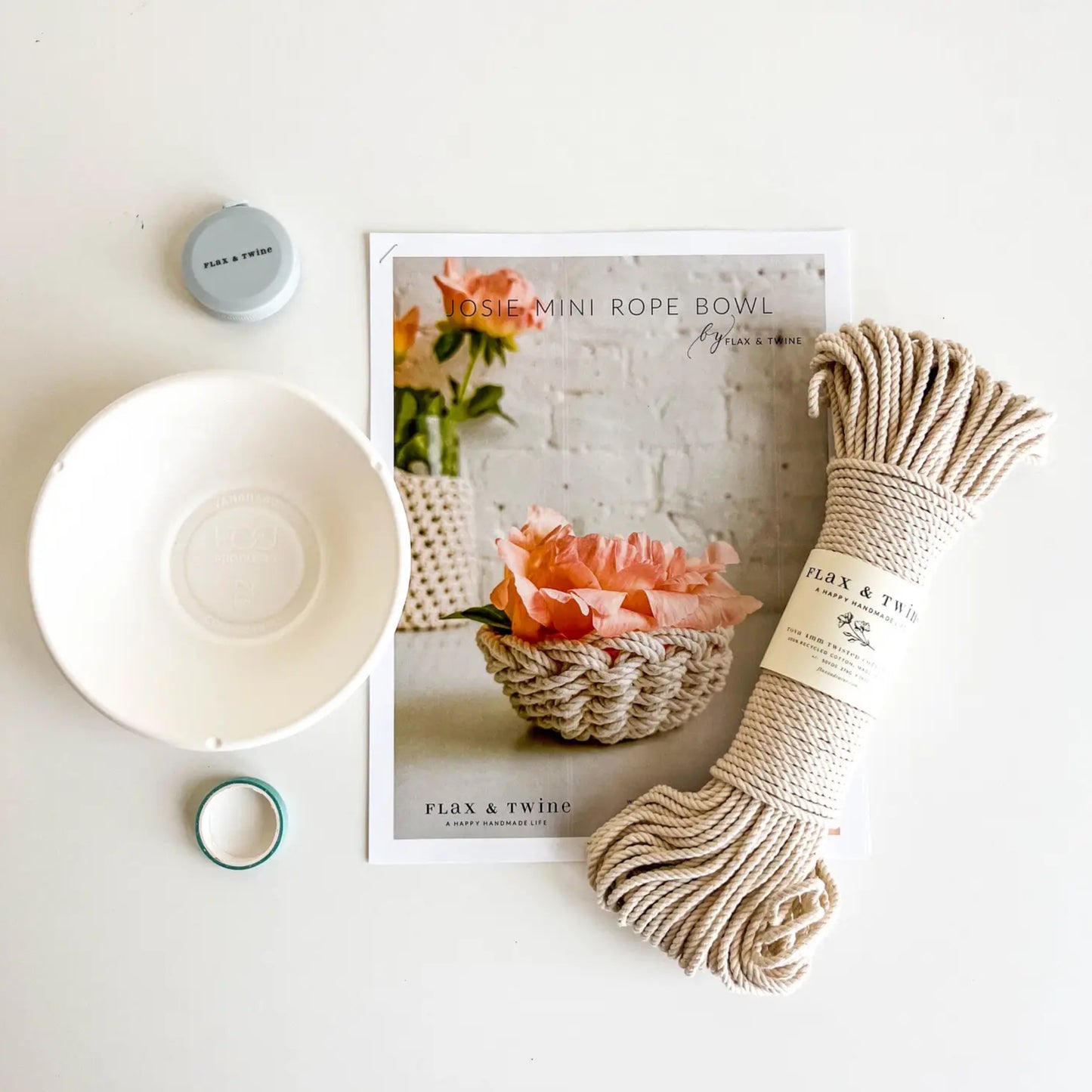 White bowl, rope, and packaging on a white surface