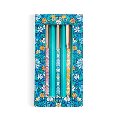 A boxed set of three decorative pens in a floral-patterned turquoise package. The pens have colorful floral handles and metallic gold caps, with the brand name 'Liberty' visible at the top of the box.