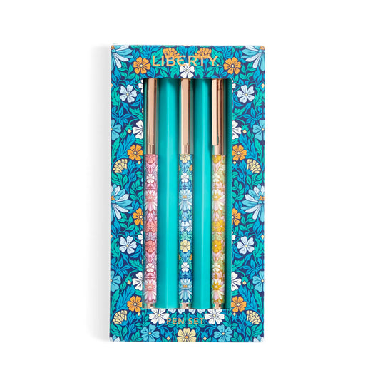 A boxed set of three decorative pens in a floral-patterned turquoise package. The pens have colorful floral handles and metallic gold caps, with the brand name 'Liberty' visible at the top of the box.