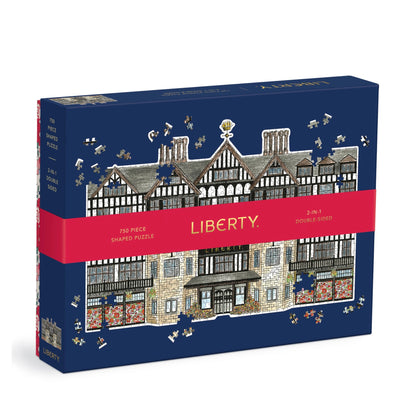 A boxed jigsaw puzzle on a white background. The box is dark blue with an illustrated timber-frame building and scattered puzzle-piece graphics.