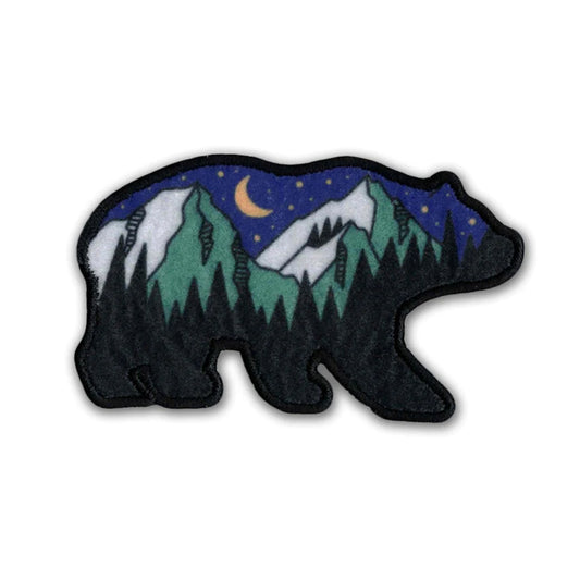 Bear-shaped patch with mountain and night sky design on a white background