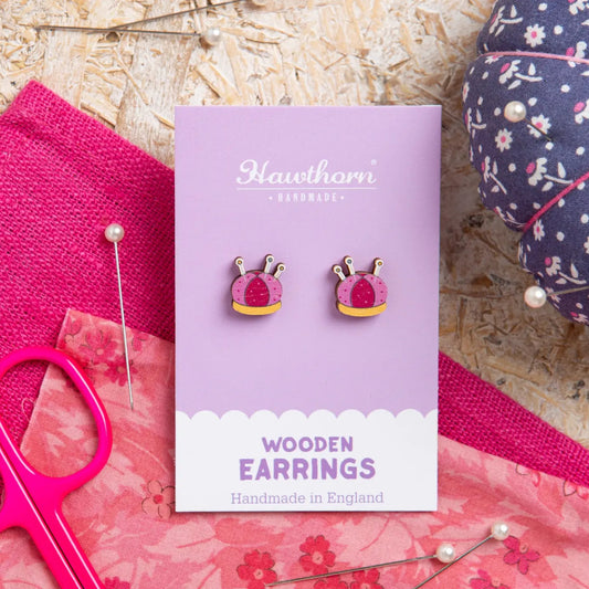 Wooden earrings on a Hawthorn brand card with pink and floral background