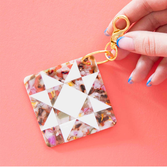 Keychain with geometric design on a pink background