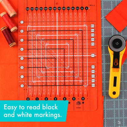 Quilting ruler with black and white markings on an orange background, accompanied by a rotary cutter.
