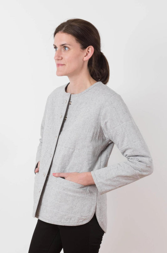 Woman wearing a light gray jacket on a white background