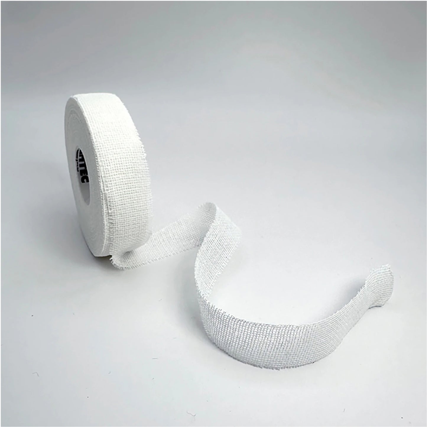Roll of white elastic bandage on a light gray background