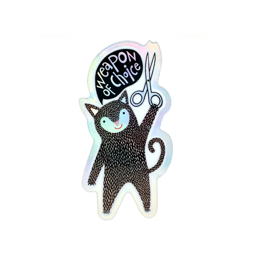 Sticker of a cat holding scissors with 'Weapon of Choice' text on a white background