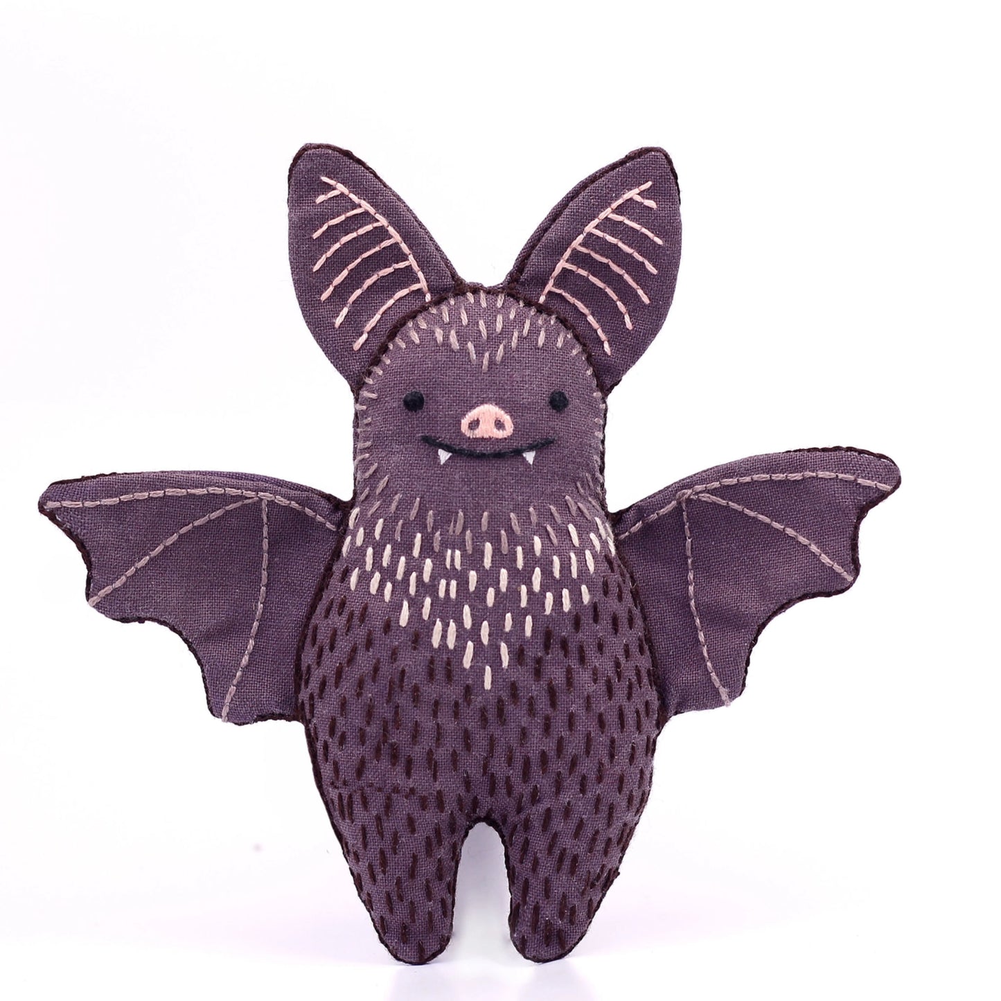 Stuffed bat toy with a purple body and wings on a white background