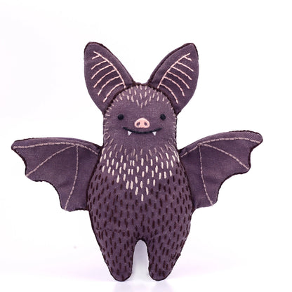 Stuffed bat toy with a purple body and wings on a white background