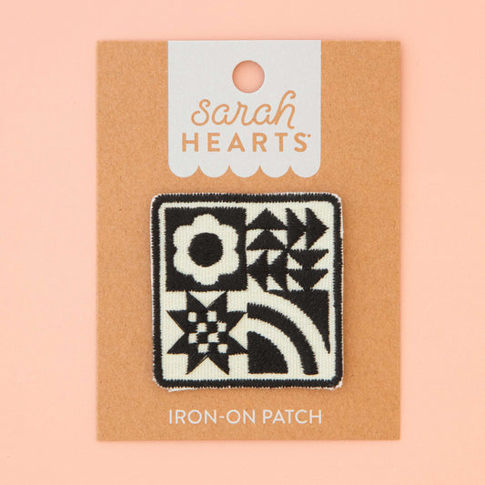 Iron-on patch with quilt block design on a 'Sarah Hearts' branded card against a pink background