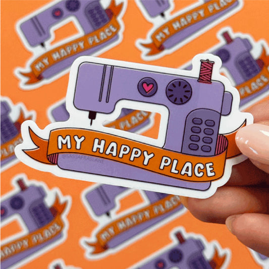 Sticker of a sewing machine with 'My Happy Place' text held over a patterned background.
