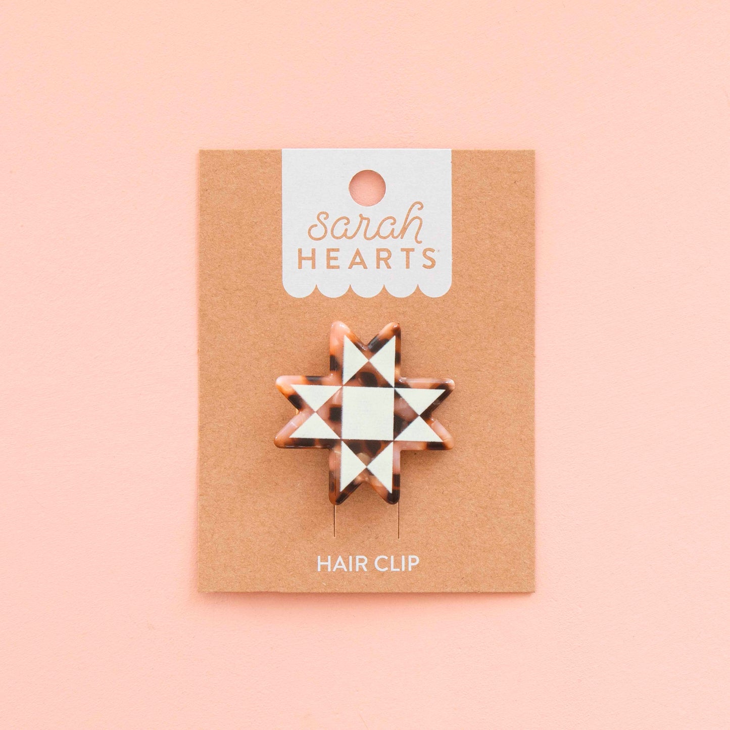 Hair clip on a 'sarah HEARTS' branded card against a pink background
