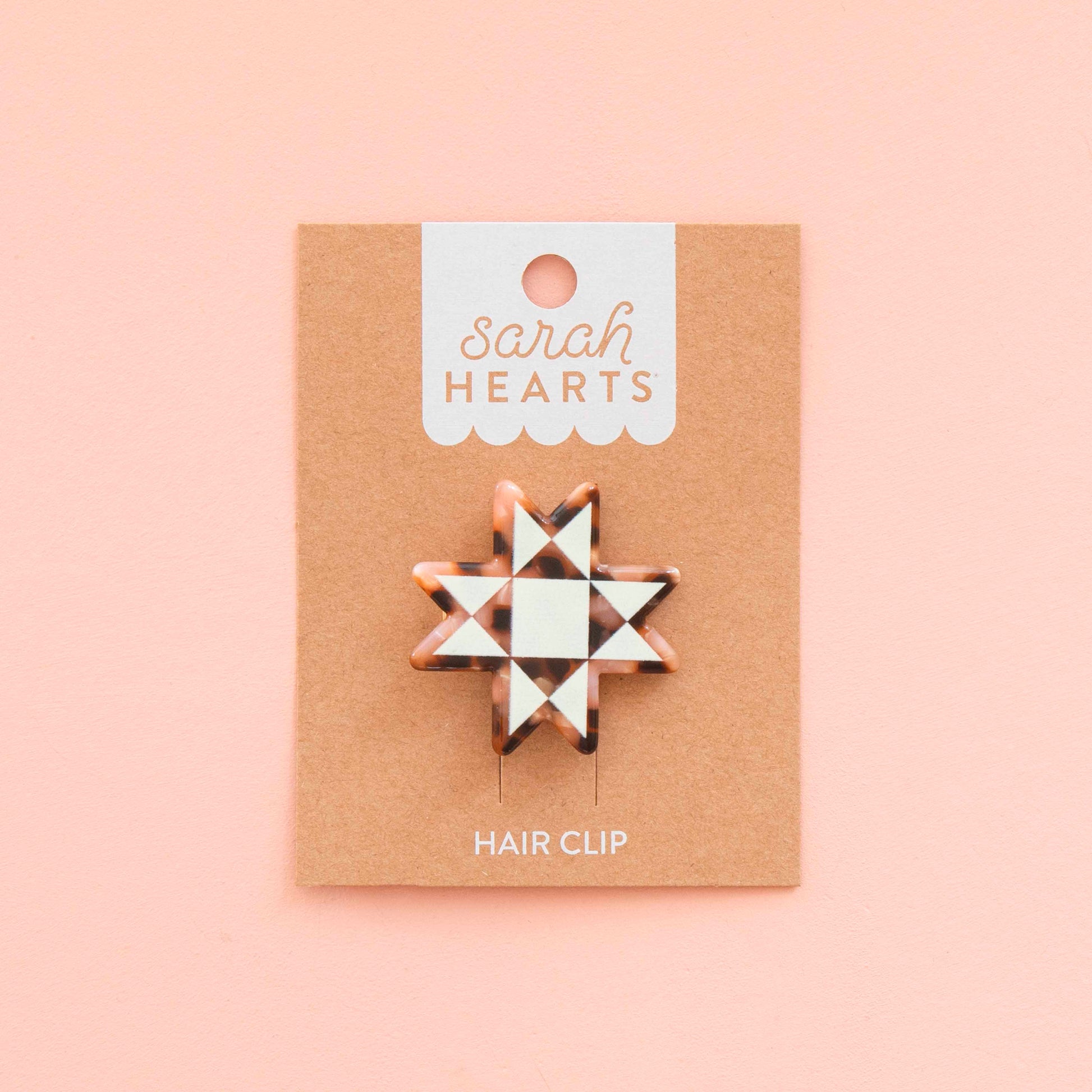 Hair clip on a 'sarah HEARTS' branded card against a pink background