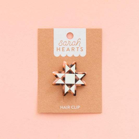 Hair clip on a 'sarah HEARTS' branded card against a pink background
