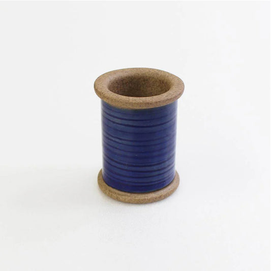 Ceramic spool with blue center on a white background