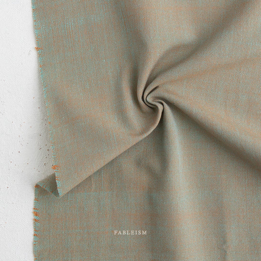 Close-up of textured fabric with 'Fableism' branding on a light background