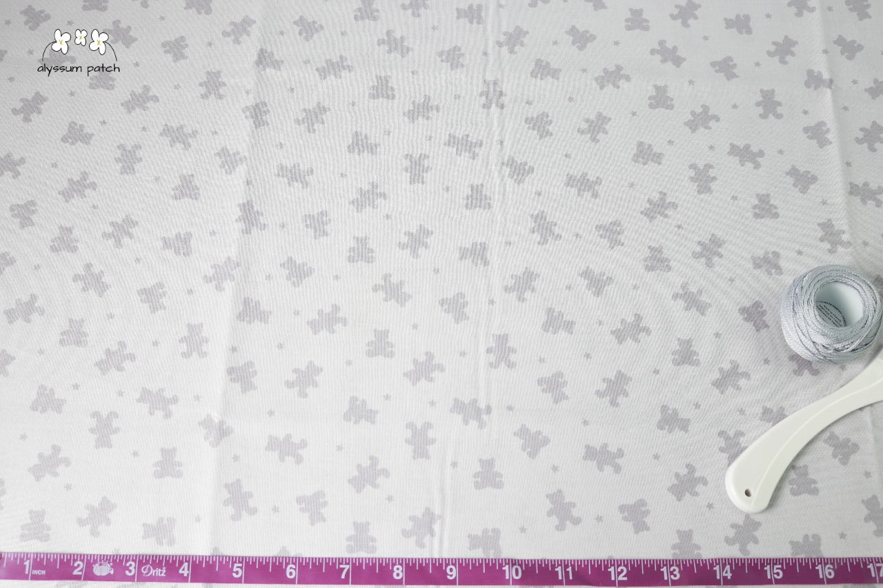 Grey on Grey Bears fabric with tape measurer and sewing tools to show scale of pattern image